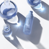 A thin woman in a white bathing suit standing in front of a teal background